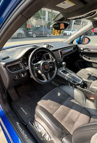 Intérieur Porsche Macan, cuir noir et volant, cadré sur l'habitacle