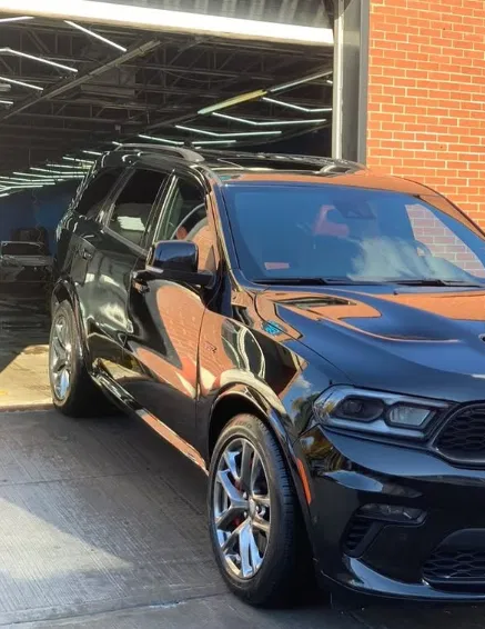 Dodge Durango SRT noir dans un espace sombre, carrosserie polie